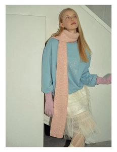 Close-up of soft pink knitted scarf with blue sweatshirt and white layered lace skirt
