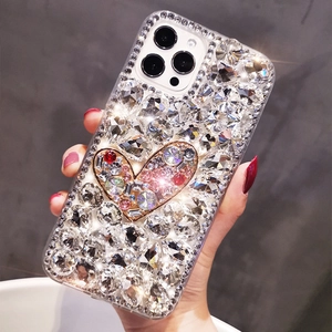 Detailed view of luxury iPhone case with handmade colorful diamonds and a golden heart
