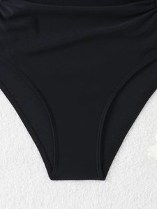 Detailed macro view of black swimsuit bottom showing high-quality reinforced double stitching