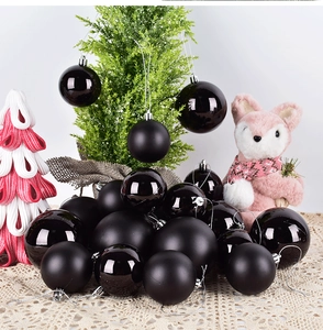 Detail of black Christmas ornaments in matte and glossy finishes on lace fabric