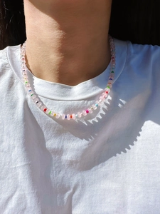 Macro shot of colorful beaded necklace with pink quartz and turquoise under natural light