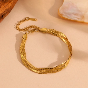 Detail view of a multi-strand gold-plated stainless steel chain bracelet with lobster clasp