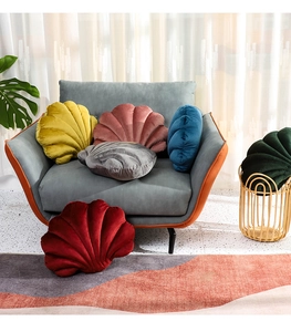 Detailed view of colorful shell-shaped velvet pillows arranged on a living room sofa