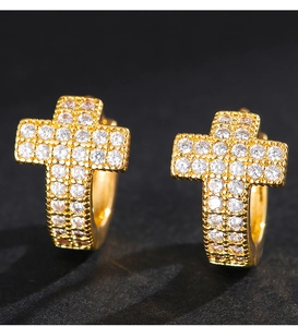 Macro shot of gold cross earrings with white pavé zircons on a dark grey surface