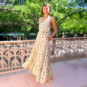 Detail of halter neck design and tropical palm tree print on sleeveless summer maxi dress