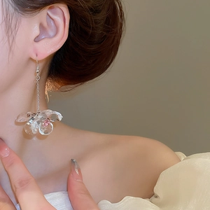 Close-up of vintage flower drop earring with pink crystal center on silver hook