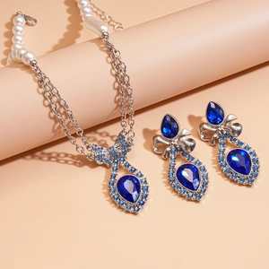 Elegant silver bow necklace and earrings set with blue teardrop crystals and pearls