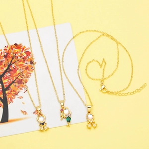 Close-up of golden mermaid pendant necklaces with colorful zircon stones and autumn leaf card