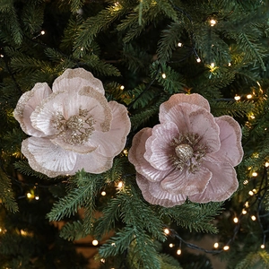 Pink velvet Christmas magnolia flower with gold glitter decor on a festive Xmas tree
