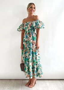 Detail of off-shoulder floral dress featuring puff sleeves and tiered ruffled maxi skirt