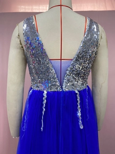 Détail de paillettes argentées et mesh sur le dos d'une robe de soirée sexy à col en V