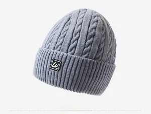 Detailed view of the gray cable knit beanie with thick fleece lining and 'W' logo patch