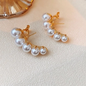 Elegant gold curved stud earrings with five white pearls in a graduated arc design