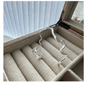 Detail of silver wavy textured ring and matching open bangle in a wooden jewelry box