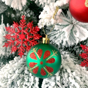 Dettaglio della pallina di Natale verde con motivi rossi e ornamento a fiocco di neve