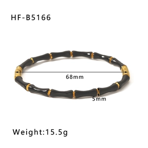 Macro detail of black enamel bamboo style bangle with gold joints and dimensions info