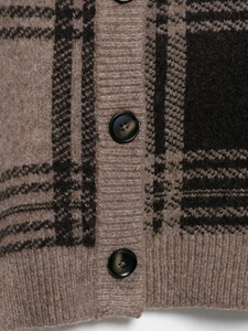 Detail of classic plaid knitted cardigan with round buttons and soft wool texture