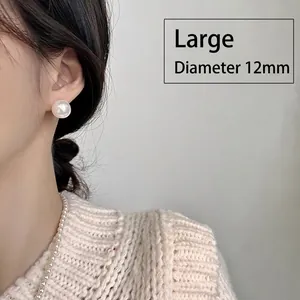 Close-up of 12mm large pearl stud earring worn by model for elegant styling