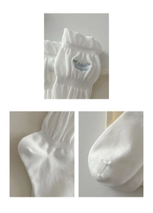 Macro detail of white socks with blue embroidery, ruffle cuffs and reinforced sewing