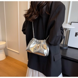 Chic silver metallic pleated chain bag with pearl pendant detail on model's shoulder