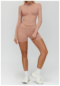 Détail d'un ensemble de yoga côtelé rose avec manches à passe-pouce et short de sport taille haute