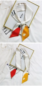 Detailed view of cream satin hair scarf with minimalist red and yellow portrait art pattern