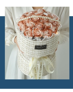 Detail of elegant orange soap rose bouquet in woven gift box with pearl handle