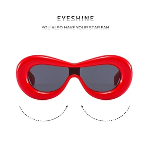 Detail of red oversized Y2K chunky frame sunglasses with dark grey lenses in macro view