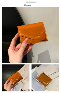 Close-up of a stylish bright orange glossy envelope card wallet with fine stitching