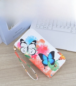 Detailed view of long zip-around wallet with colorful butterfly and sunflower prints