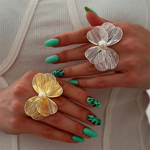 Detailed view of large flower ring with metallic petals and a white center pearl accent