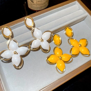 Détail de boucles d'oreilles fleuries avec pétales brillants sur présentoir en velours