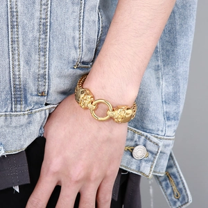 Close-up of punk style gold skull bracelet with stainless steel mesh chain on model