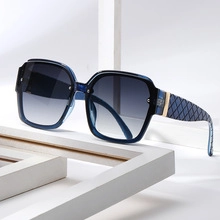 Detail of blue gradient oversized square sunglasses with gold metal hinges and quilted temples