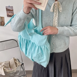Hellblaue plissierte Canvas-Einkaufstasche kombiniert mit Strickjacke und Rock