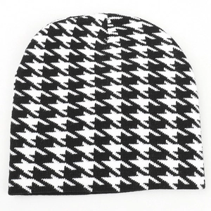 Detailed close-up of houndstooth knit pattern and black cuffed hem of the winter beanie
