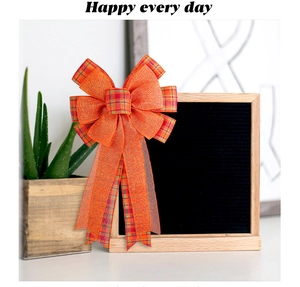 Detail view of large orange plaid bow with long ribbon on a black felt letter board
