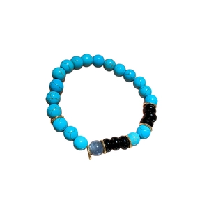 Bohemian beaded bracelet with turquoise, agate, and gold metal spacers on white background