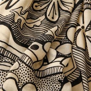 Close-up of lightweight beige cotton linen scarf with black tribal geometric patterns