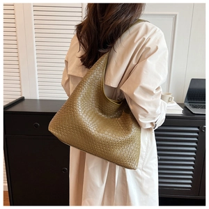 Detail of olive green woven leather texture on a large hobo shoulder bag for women
