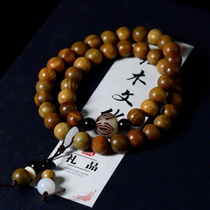 Detailed macro view of natural green sandalwood double-loop bracelet with lotus charm