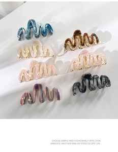 Detailed array of stylish wavy acetate hair claws in various marble and amber patterns