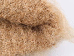 Dettaglio macro della morbida texture in maglia marrone con fibre lunghe e soffici