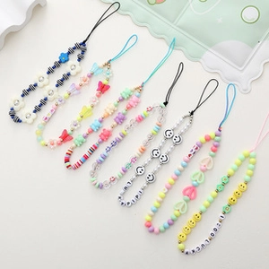 Detail of colorful beaded phone straps with happy face, flower, and heart charms
