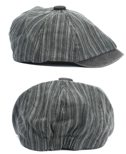Close-up of the fine vertical stripes and stitching on a dark grey newsboy cap