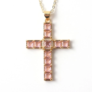Macro view of gold cross pendant necklace with square pink zircons and crystal detail