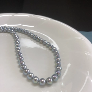 Macro shot of silver-blue round pearls with metallic luster on S925 silver necklace