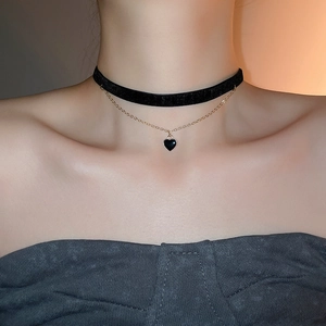 Detail of double-layer vintage choker with black velvet heart pendant and gold chain