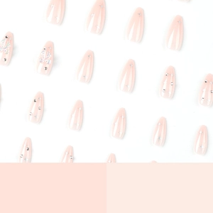 Press-on nails with 3D crystal bows, silver star designs, and almond-shaped pink finish