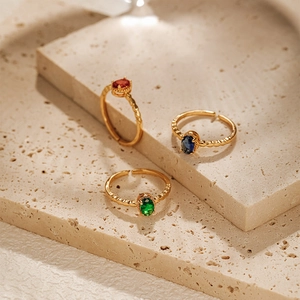 Detailed view of adjustable 18K gold plated rings featuring red, blue, and green zircons